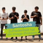 Eine Gruppe von Menschen steht nah beieinander, jede Person starrt auf ihr Handy. Davor der Schriftzug: "Santosha: Zufriedenheit hat ein Image-Problem"