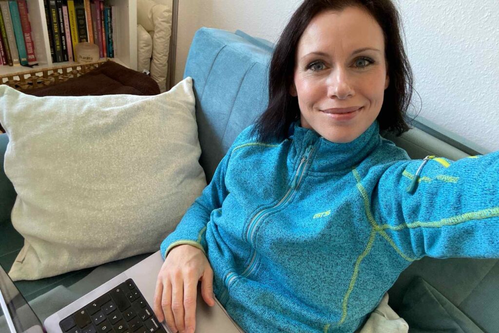 Die Meditationslehrerin Stefanie Seher mit ihrem Laptop auf der Couch